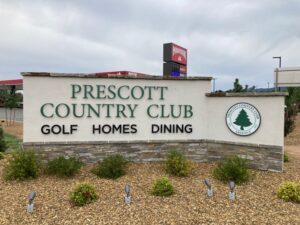 Prescott Country Club sign is shows reading "Golf, homes, and dining."