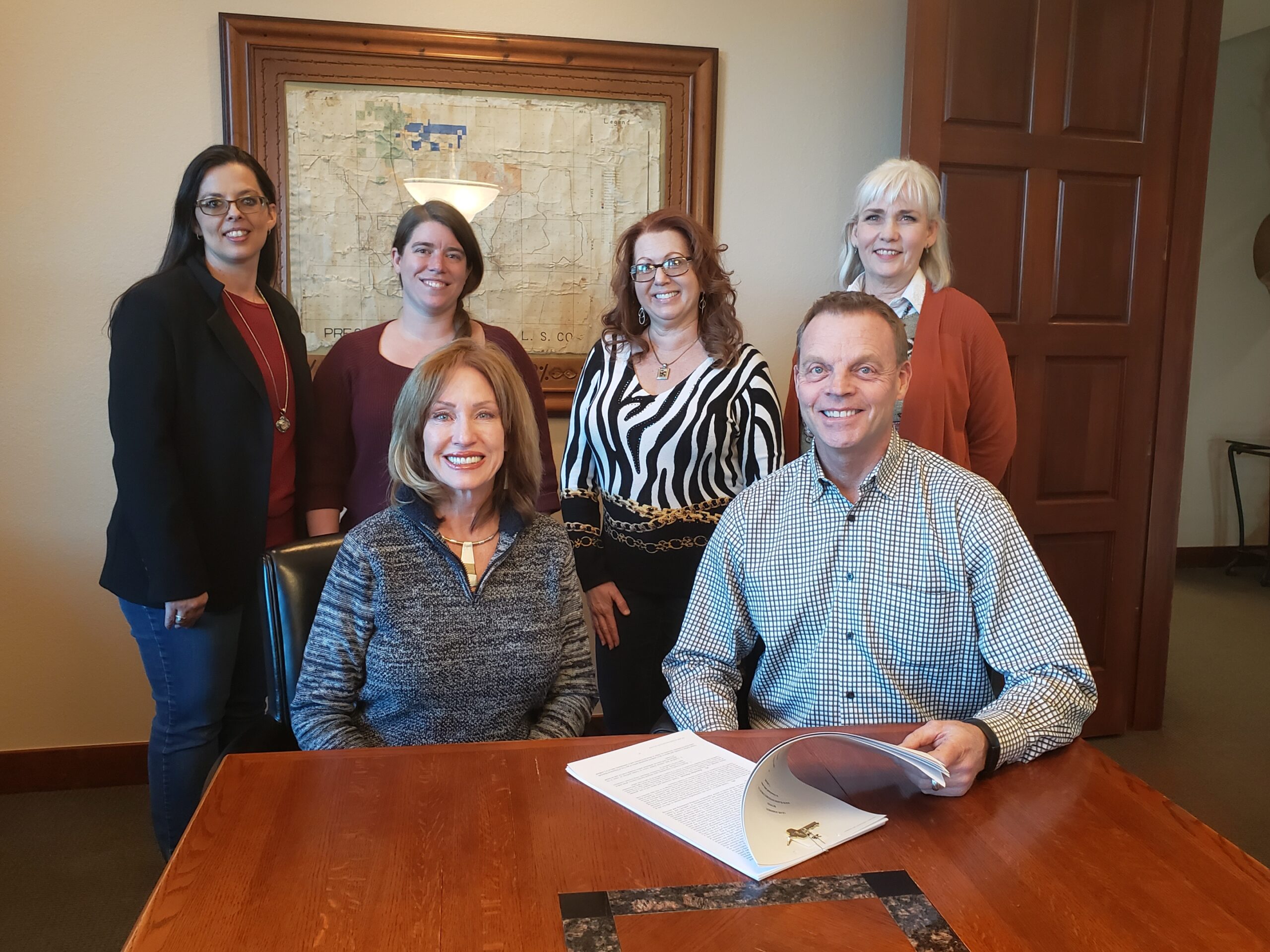 The Allstate team gathers around to sign their lease with Ron Fain.