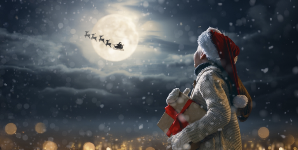 kid looking up at santa claus in the night sky