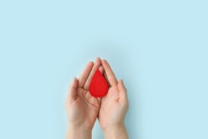 hands holding a blood symbol