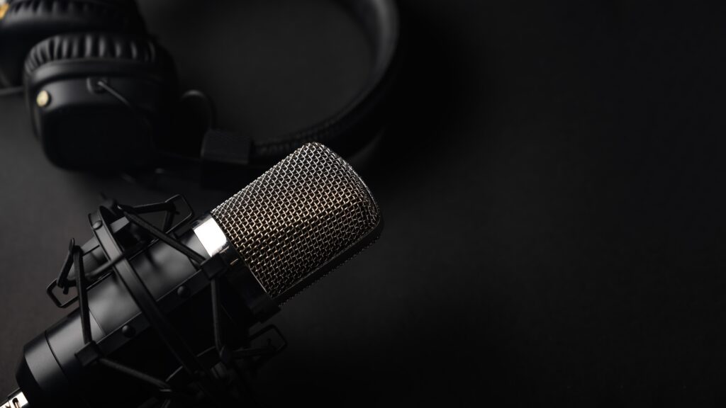 Studio black studio microphone with studio headphones on a black background.