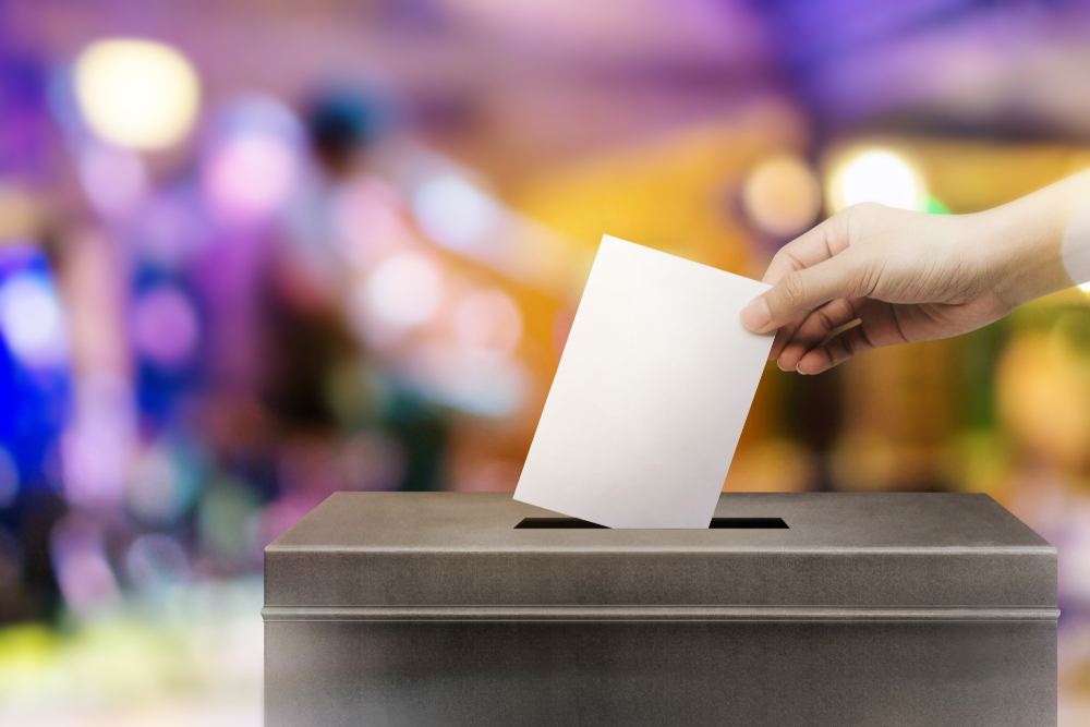 someone voting in a ballot box