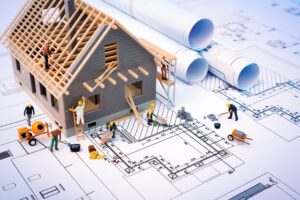 model home with construction workers on top of blueprint